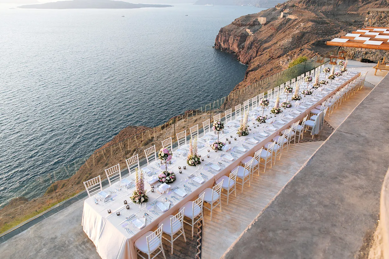 Elegant wedding reception table on a Santorini clifftop terrace